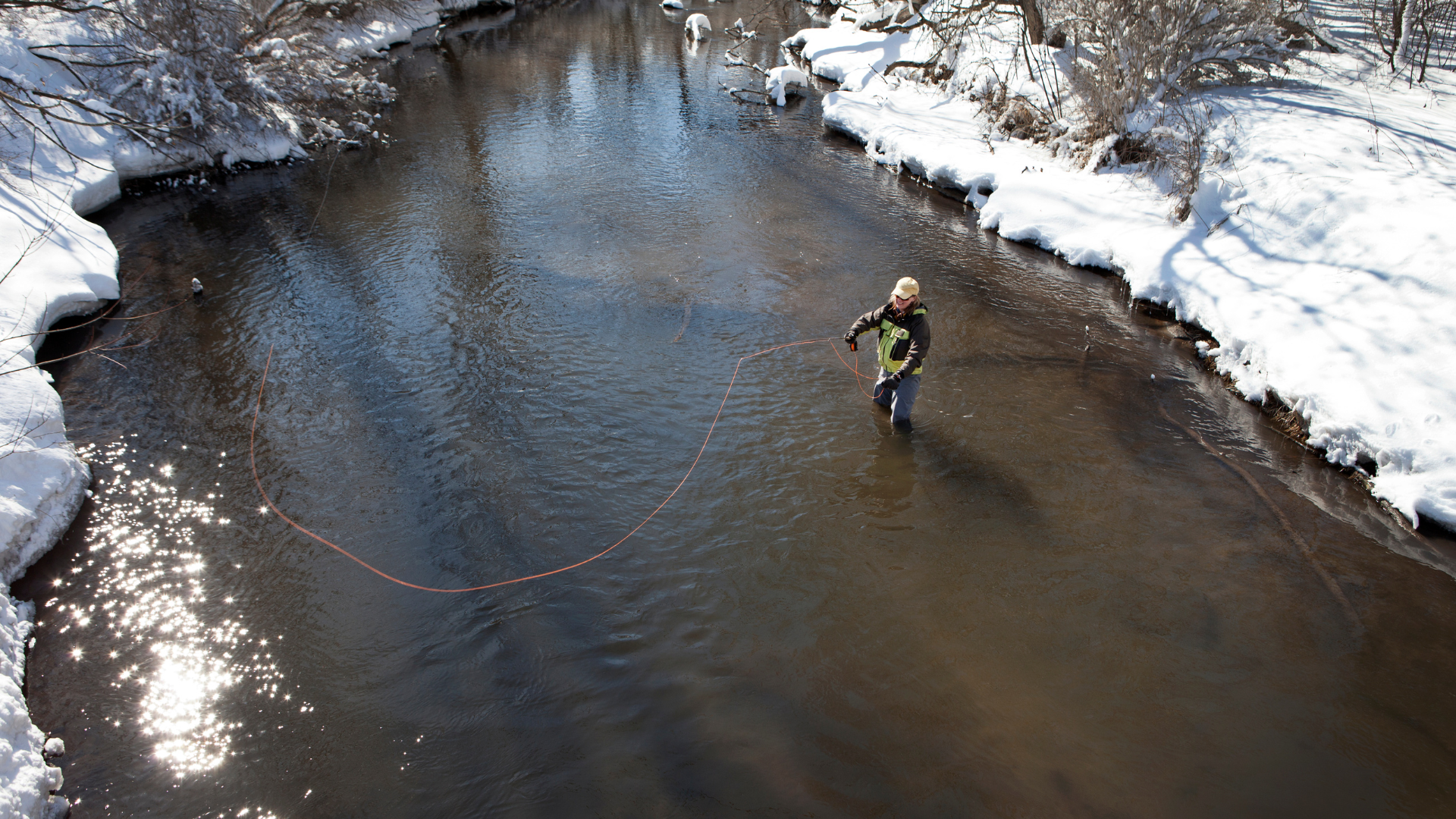 man fly fishing in ice